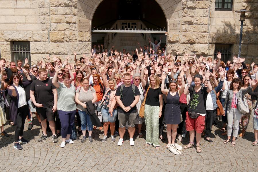 Viele Menschen winken in die Kamera