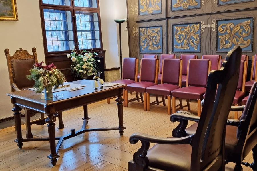 Historisches Zimmer mit Tisch und Stühlen.