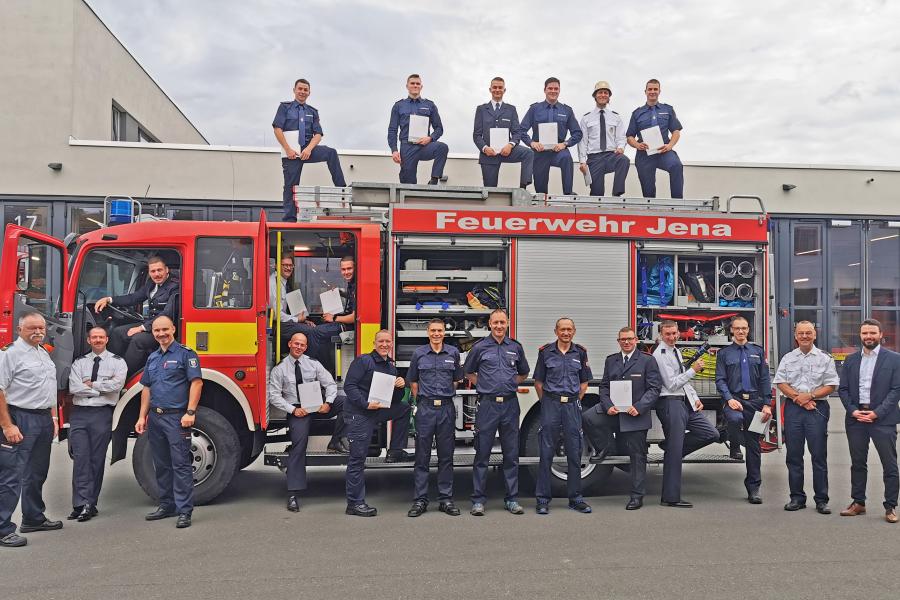 Feuerwehrleute vor Feuerwehrfahrzeug