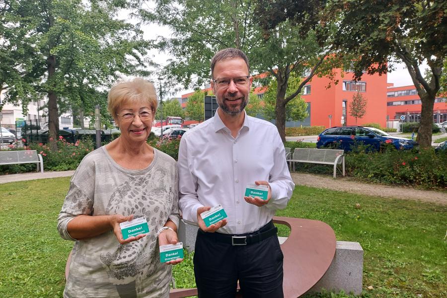 Eine Frau und ein Mann halten je zwei Chipkarten in den Händen.