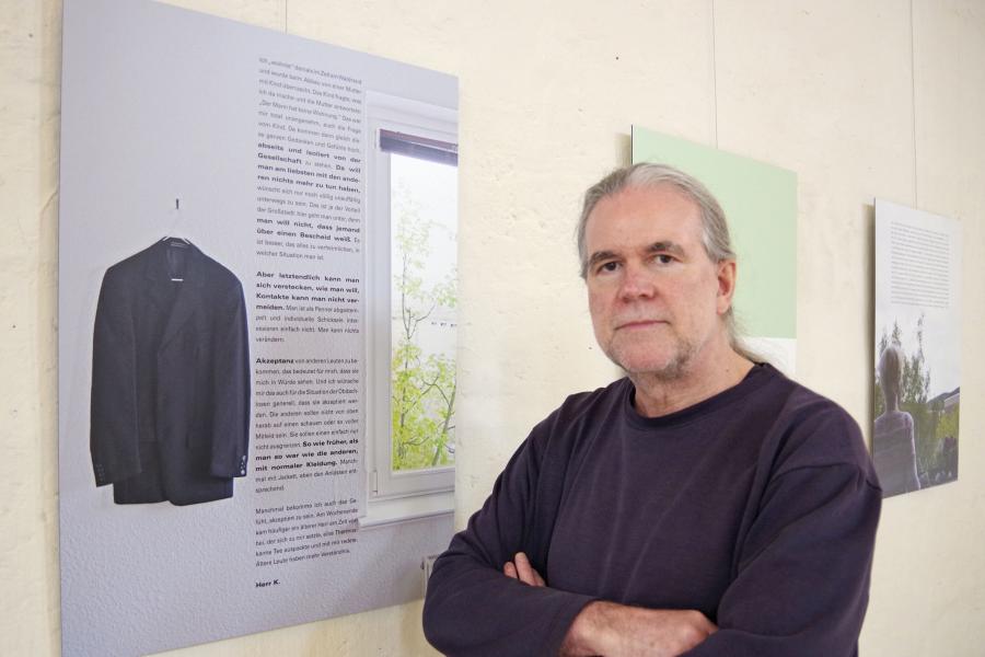 Künstler vor Ausstellungstafel