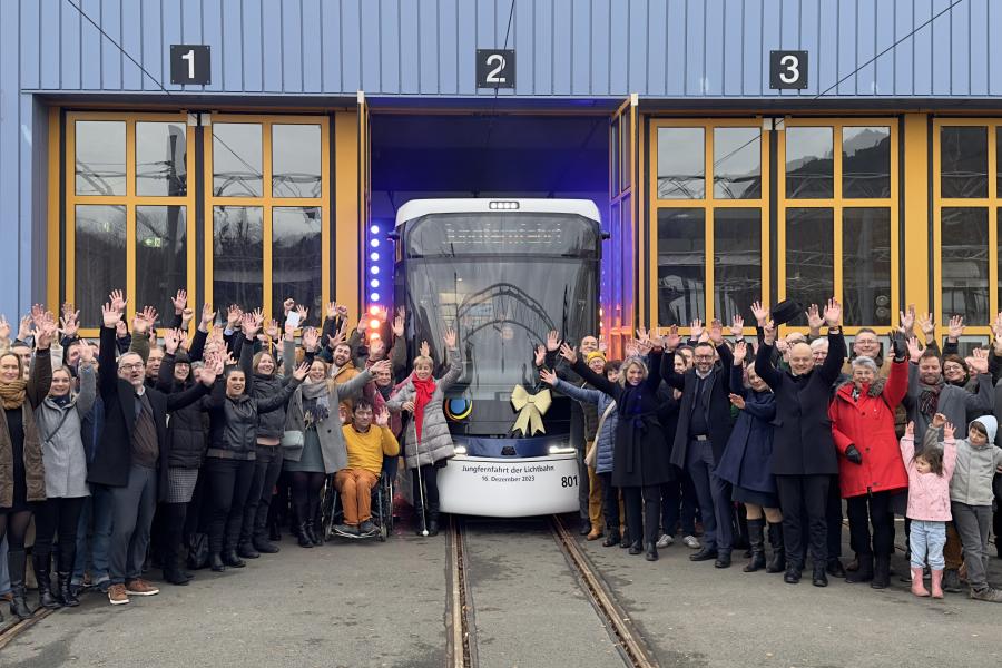 Viele Menschen begrüßen eine Straßenbahn