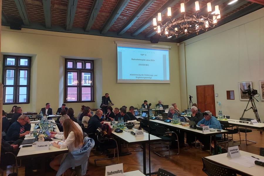 Stadtratsmitglieder sitzen an Tischen im Historischen Rathaussaal