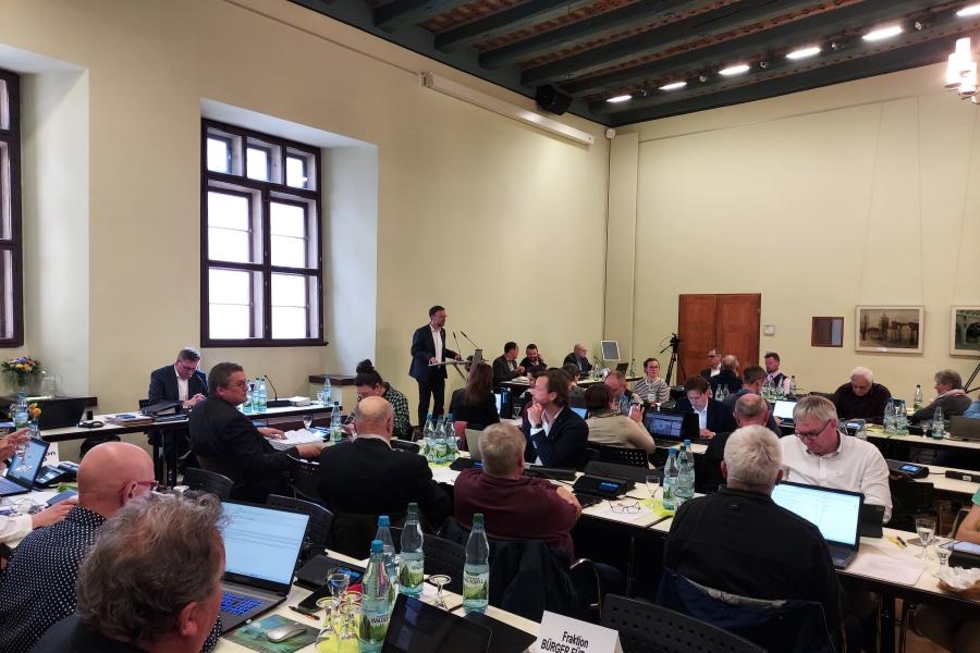 Mitglieder des Stadtrates im Historischen Plenarsaal sitzen an Tischen