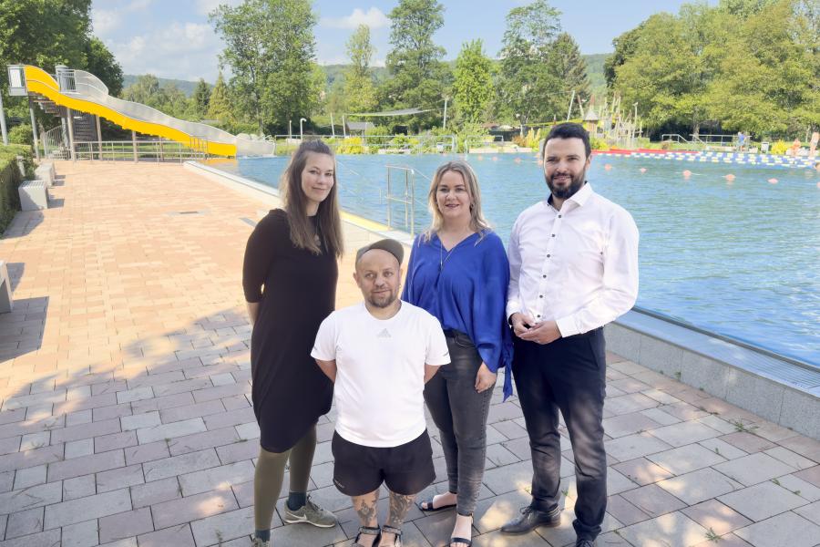 Vier Personen stehen vor einem Freibad