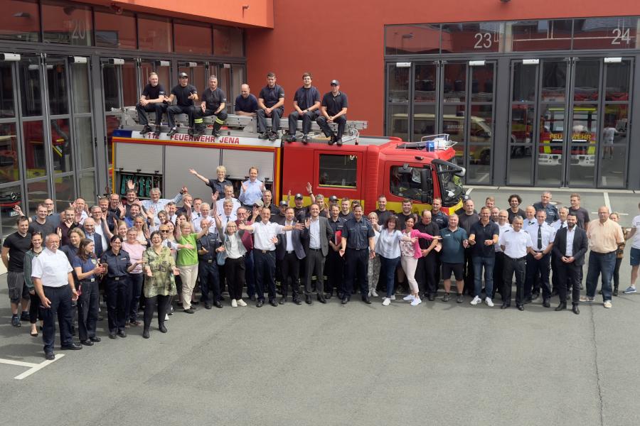 Viele Menschen vor einem Feuerwehr-Auto