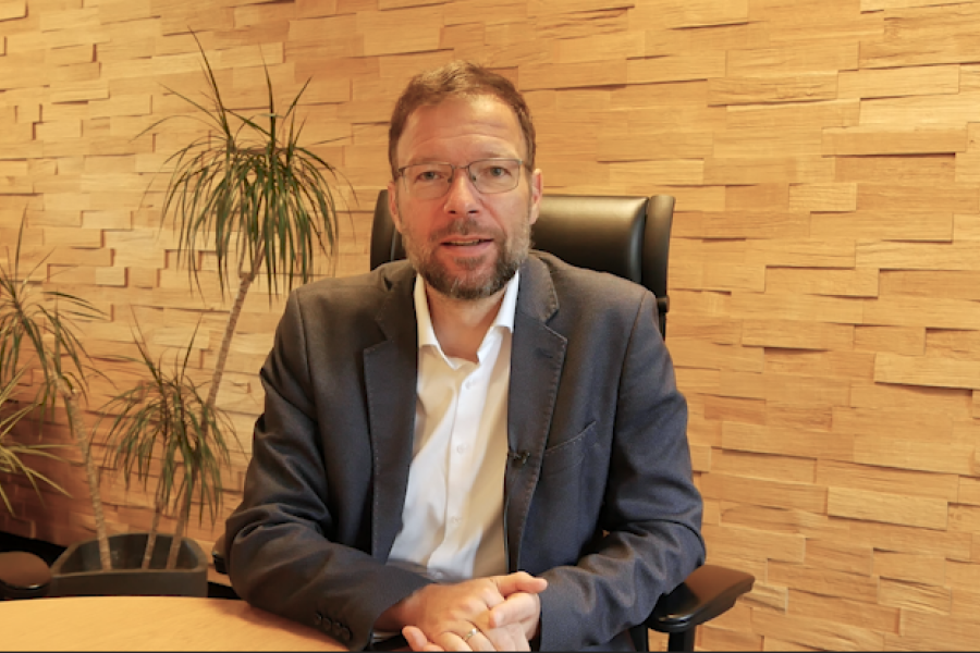 Oberbürgermeister Thomas Nitzsche sitzt am Tisch in seinem Büro und spricht seine Videobotschaft ein.