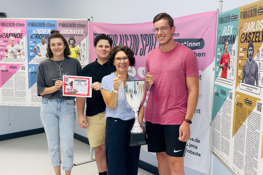 Vier Menschen halten einen Cup