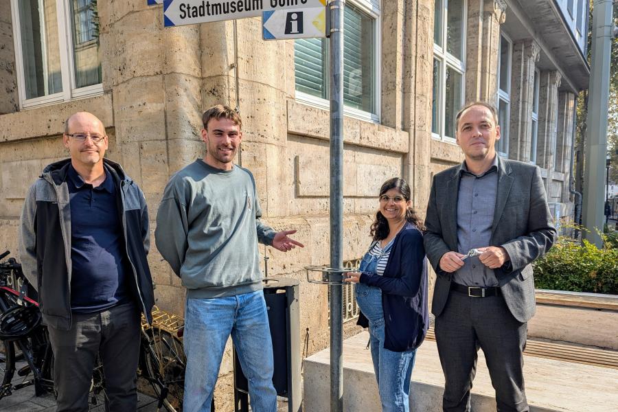 Menschen vor einem Mülleimer mit Pfandringen