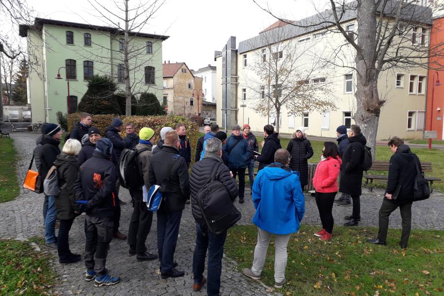 Eine Gruppe von Personen steht im Kreis am geplanten Wissenschaftscampus Bachstraße