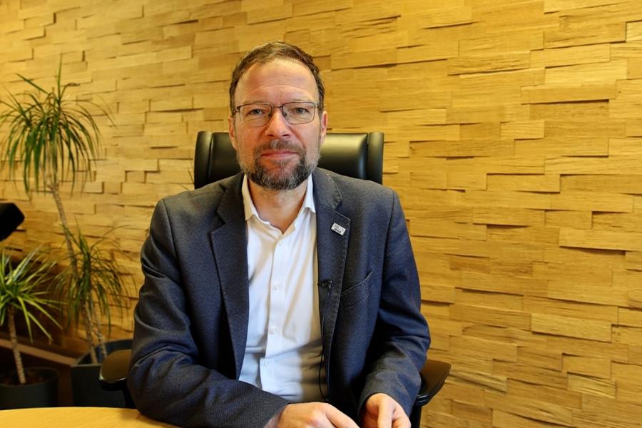 OB Thomas NItzsche sitzt in seinem Büro am Tisch und schau in die Kamera
