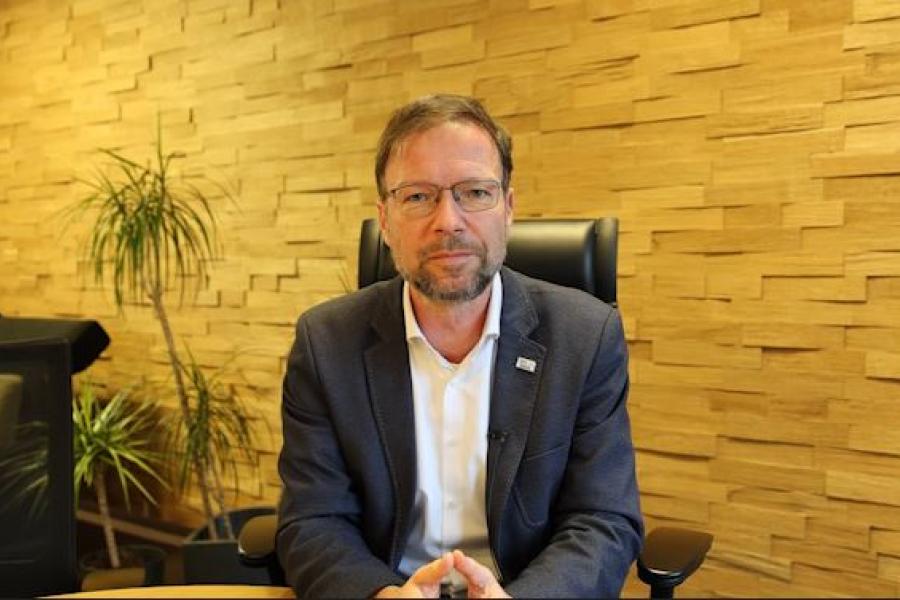 Oberbürgermeister Thomas Nitzsche sitzt an einem Tisch und blickt in die Kamera.