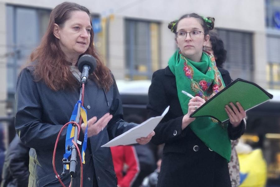 Zwei Frauen auf einer Demonstration, eine redet ins Mikrophon