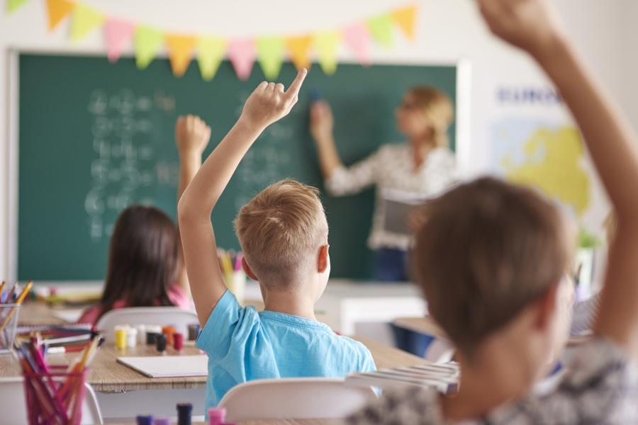 Schüler im Klassenzimmer melden sich. 