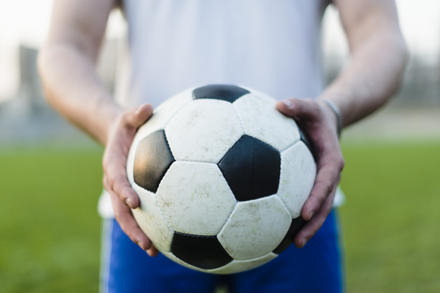 Fußball der in zwei Händen gehalten wird