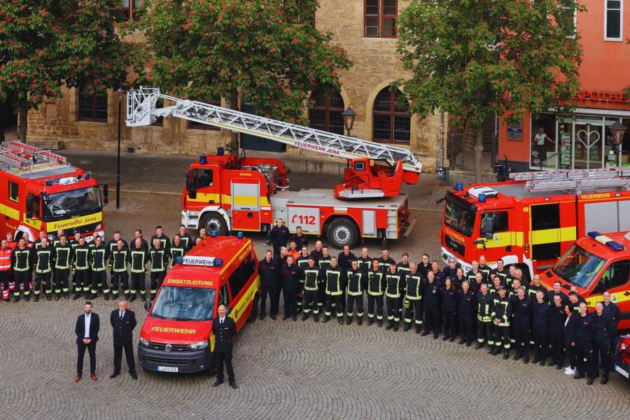 Viele Feuerwehrleute stehen vor dem Rathaus.
