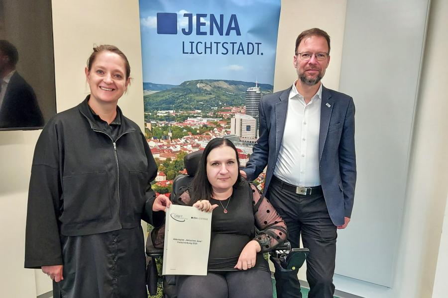 Drei Personen mit einer Broschüre