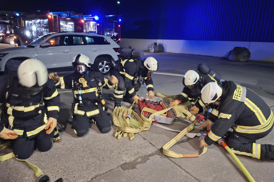 Mehrere Feuerwehrleute sortieren Schlauch
