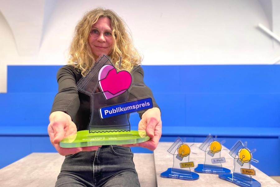 StadtLab-Projektmanagerin Grit Sachse präsentiert einen der Pokale für den StadtLab Ideenwettbewerb 2025.