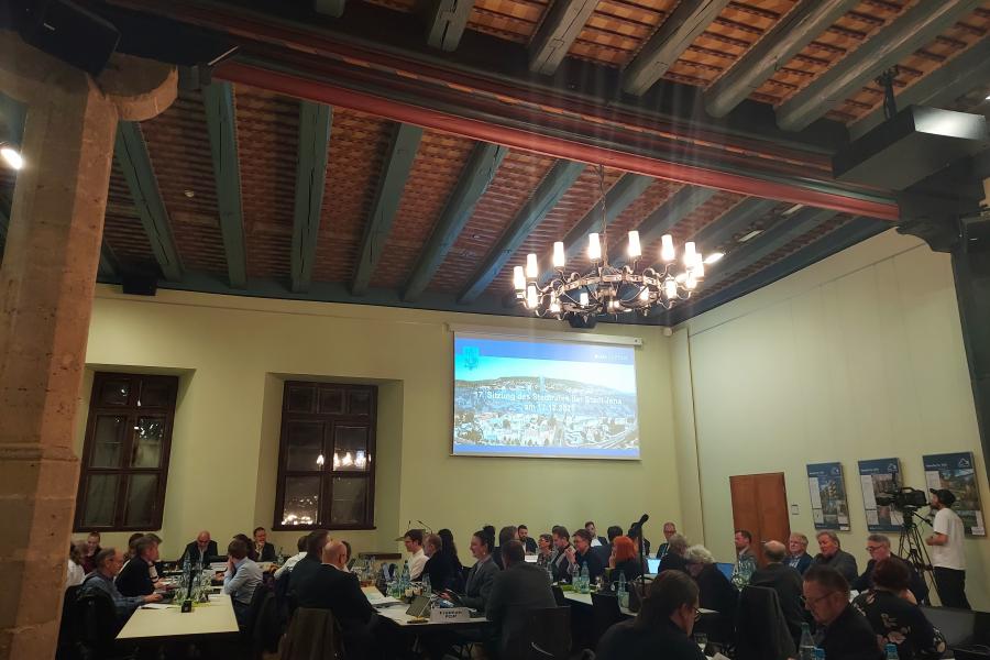 Mitglieder des Stadtrates sitzen im Historischen Rathaus an Tischen