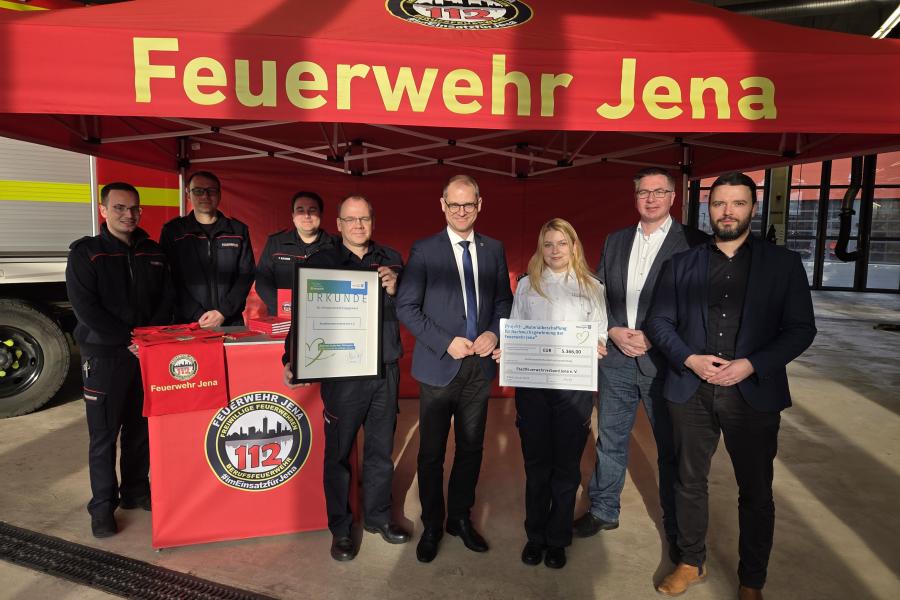 Mehrere Personen stehen vor einem Pavillon der Feuerwehr Jena und schauen in die Kamera.