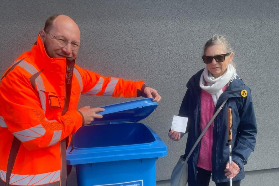 Martin Steglitz und Beatrix Adloff haben den ersten Aufkleber auf einer blauen Tonne angebracht.
