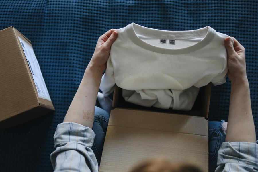 Person hält T-Shirt in der Hand.