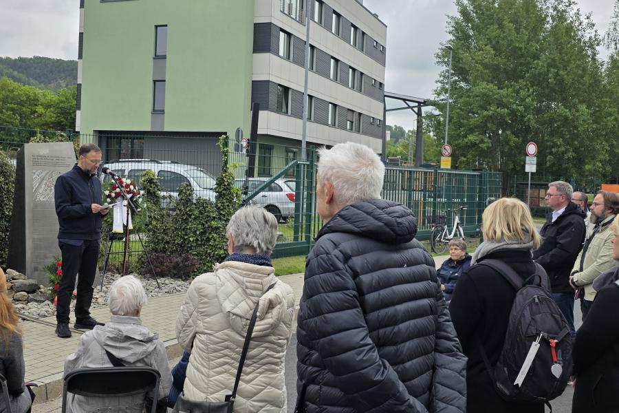 Oberbürgermeister Dr. Thomas Nitzsche steht an einem Mikrofon vor einer Gedenkstele, neben ihm ist ein Kranz aufgebaut, im Vordergrund stehen Zuhörerinnen und Zuhörer.