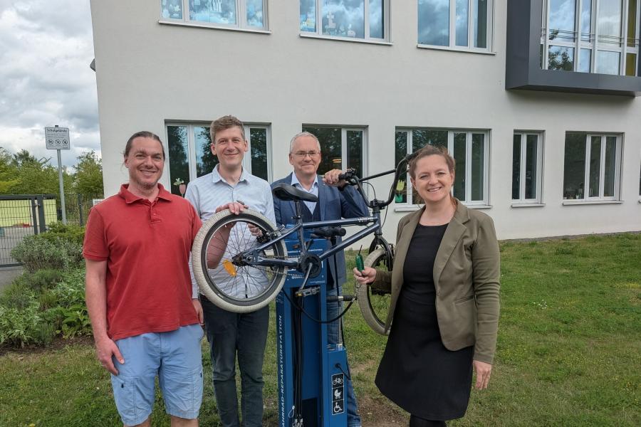 Vier Personen stellen die Fahrrad-Reparaturstation vor