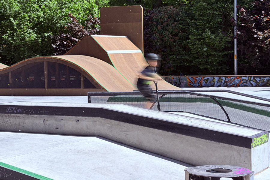 Eine junge Person fährt auf einer Skatebahn