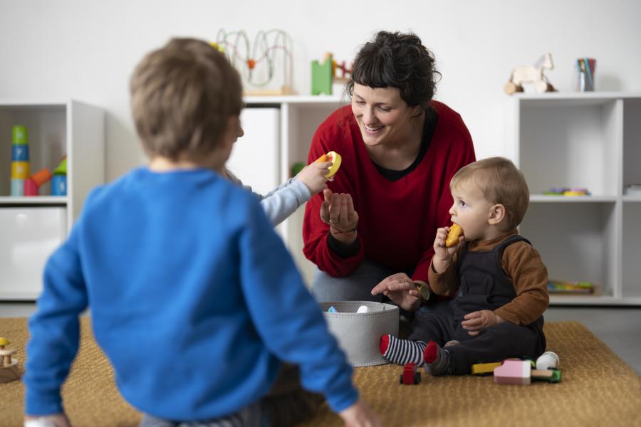 Frau hilft Kleinkindern