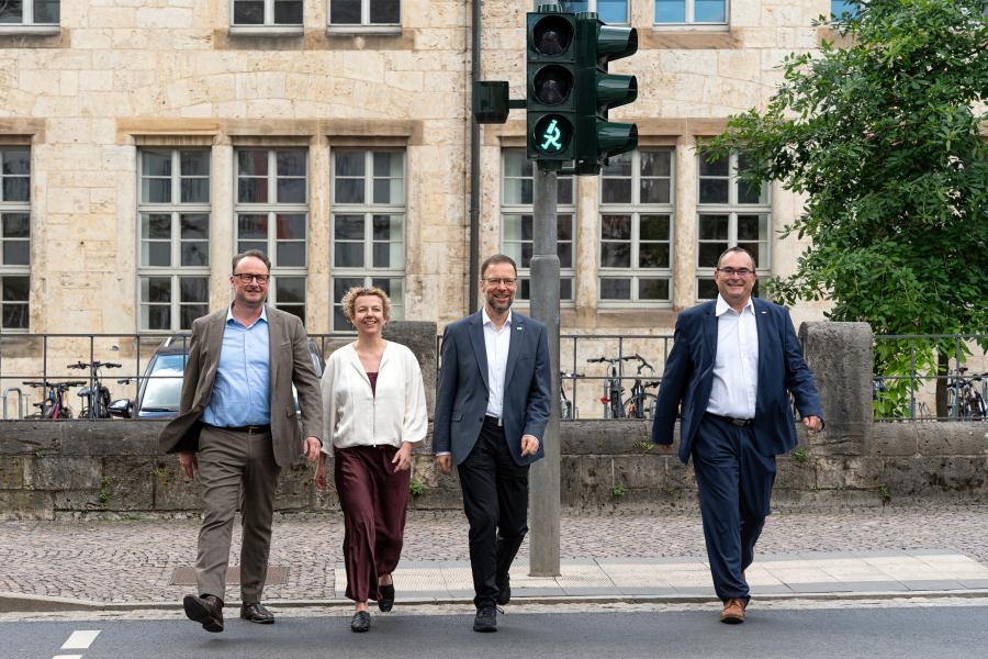 Vier Personen an einem Fußgängerüberweg 
