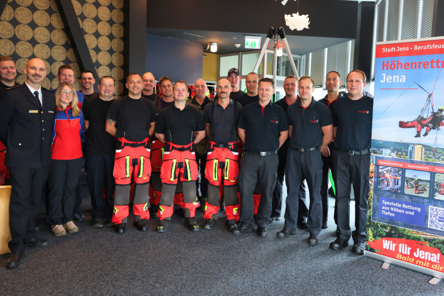 Gruppe von Menschen stehen im JenTower und lachen in die Kamera.